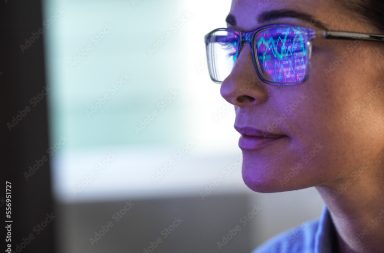 Female expert in glasses looking at screen with financial data