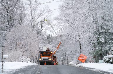 manual worker working on repair electrical line after winter snow storm
